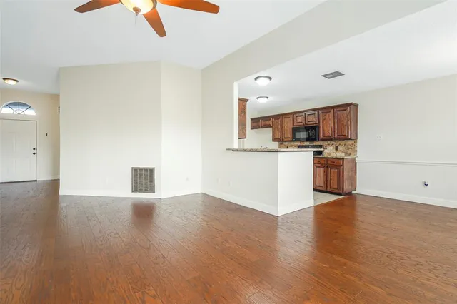 a view of a kitchen with a sink stove cabinets and empty room