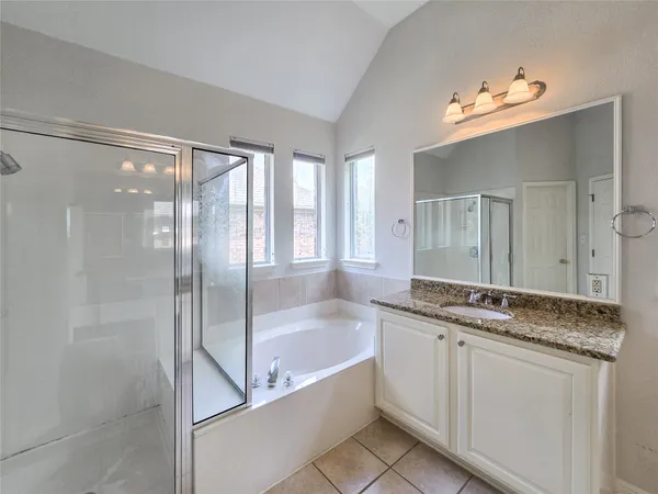 a bathroom with a granite countertop sink mirror and bathtub