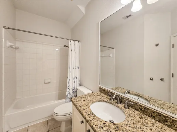 a bathroom with a granite countertop sink toilet mirror and shower