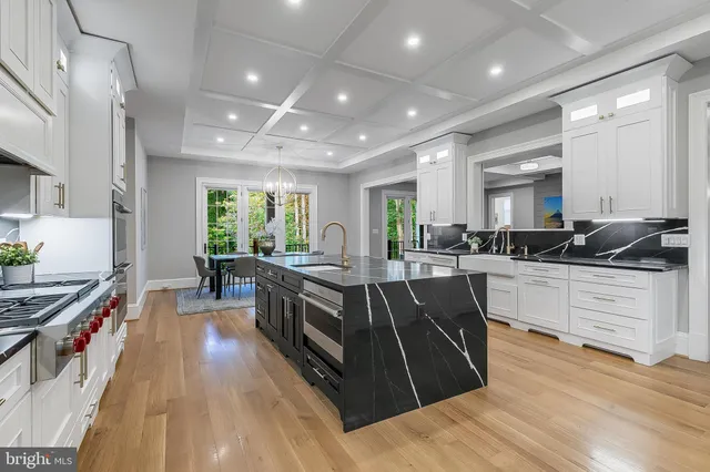a large kitchen with stainless steel appliances granite countertop a lot of counter space and wooden floors