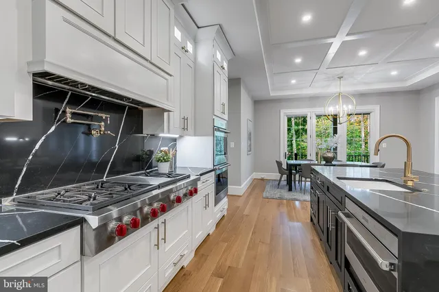 a kitchen with kitchen island granite countertop a stove and a sink