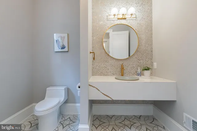 a bathroom with a toilet sink and mirror