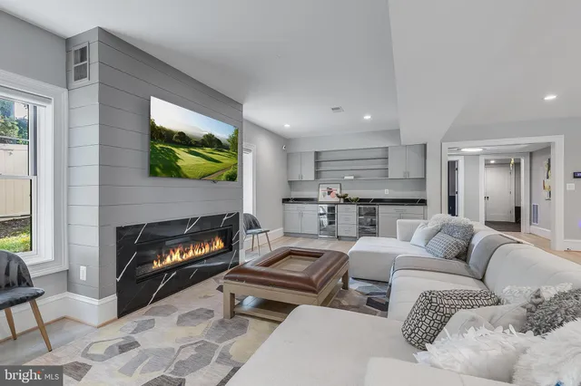 a living room with furniture a flat screen tv and a fireplace