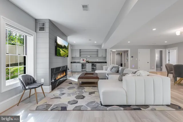 a living room with furniture a flat screen tv and a fireplace