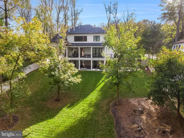 a front view of a house with garden and trees