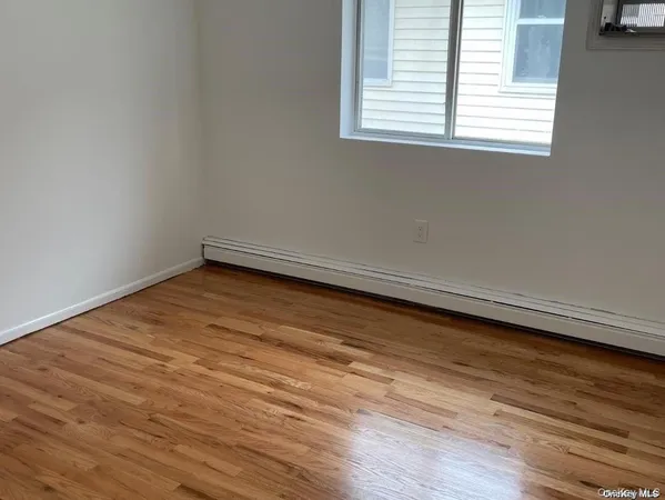 an empty room with wooden floor and a window