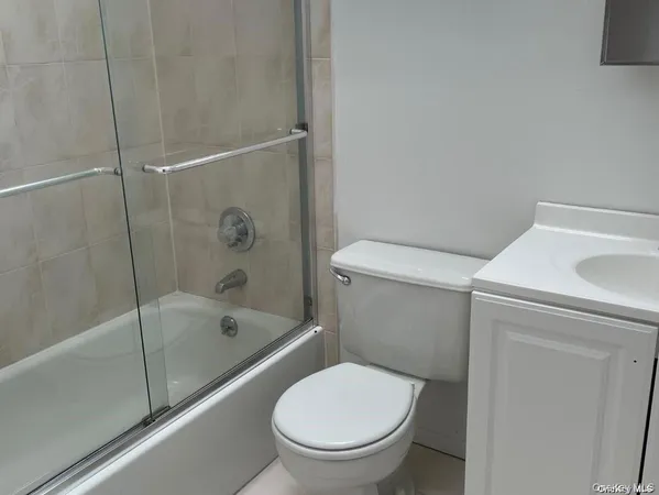 a white toilet sitting next to a bath tub