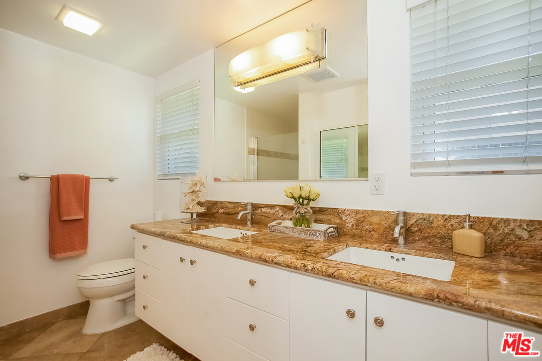 18440 Coastline Drive Malibu, CA 90265 - Photo 11 of 21 a bathroom with a granite countertop sink and a mirror