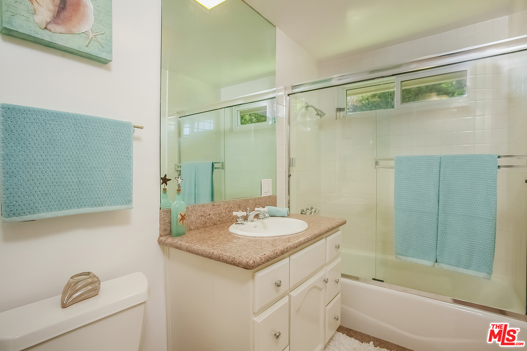 18440 Coastline Drive Malibu, CA 90265 - Photo 14 of 21 a bathroom with a granite countertop sink a toilet and shower