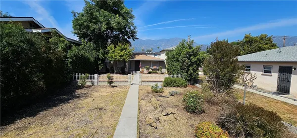 a view of a house with backyard and sitting area