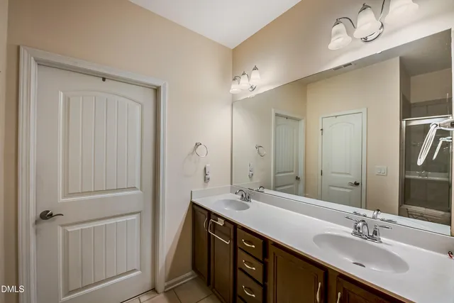 a bathroom with a double vanity sink a mirror and a bathtub