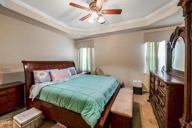 a bedroom with a bed flat screen tv and a chandelier