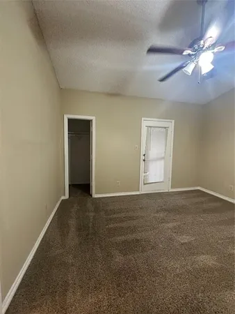 a view of an empty room with a chandelier fan