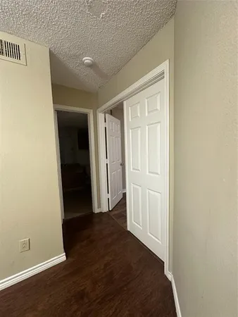 an empty room with wooden floor and closet