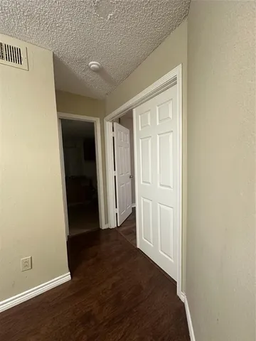 an empty room with wooden floor and closet