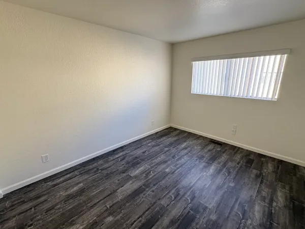 a view of a room that has wooden floor and white walls