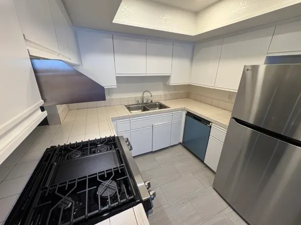 a kitchen with sink a refrigerator and a stove