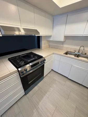 a kitchen with granite countertop a stove and a sink