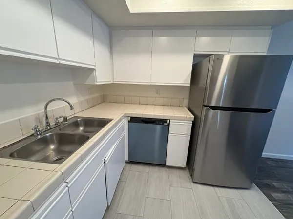 a kitchen with a refrigerator sink and cabinets