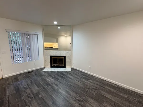 a view of an empty room with a fireplace and a window