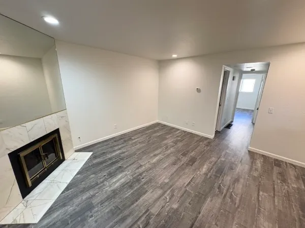 an empty room with wooden floor and fireplace