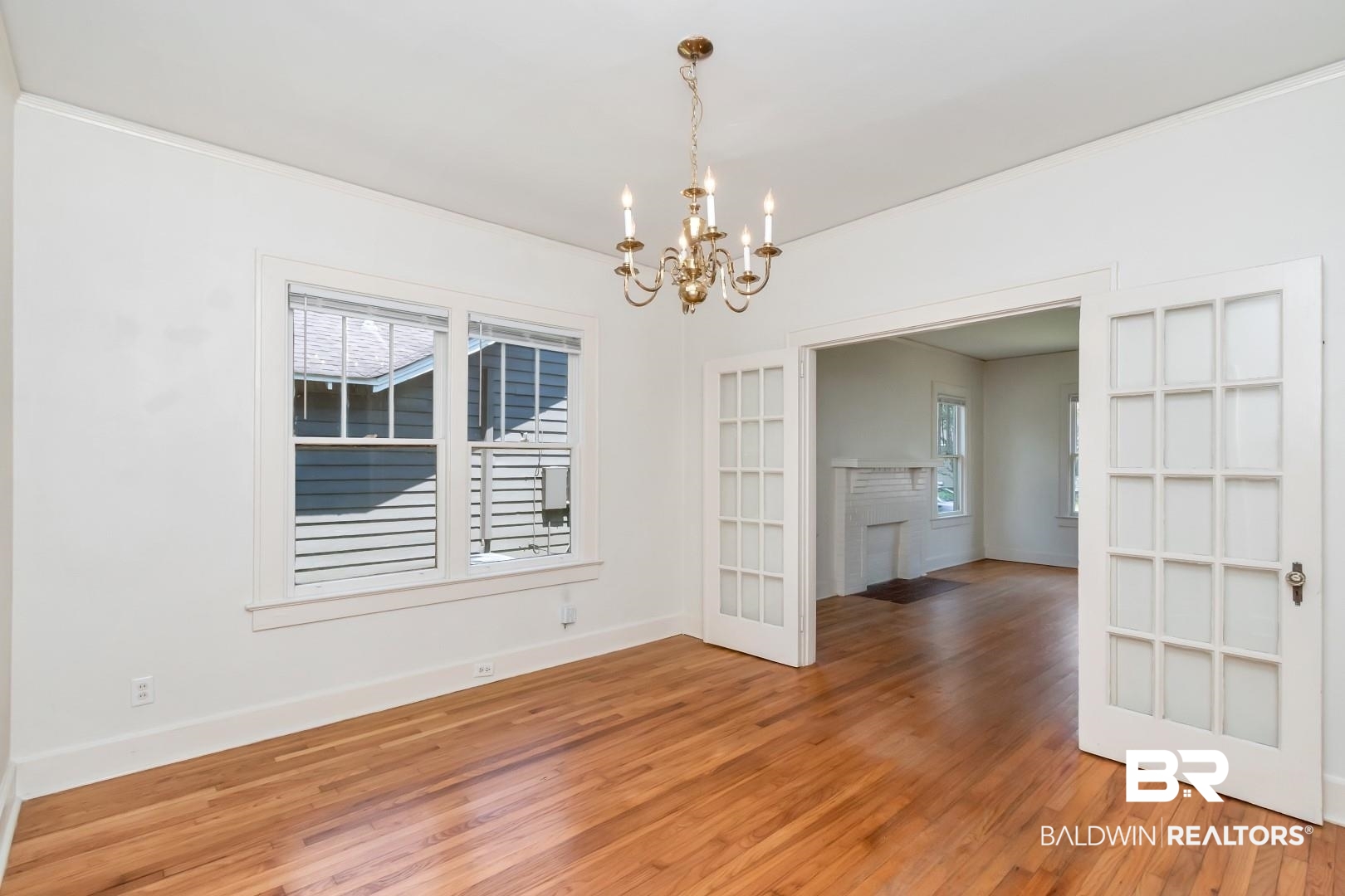 112 South Fulton Street Mobile, AL 36606 - Photo 10 of 35 Empty room featuring a chandelier and hardwood / wood-style floors