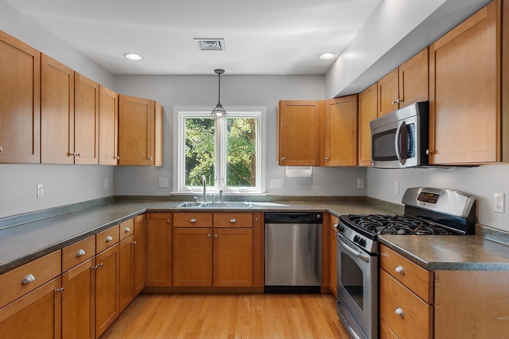 40 Grandview Road Chelmsford, MA 01824 - Photo 37 of 42 a kitchen with stainless steel appliances granite countertop wooden cabinets a stove a sink and a microwave