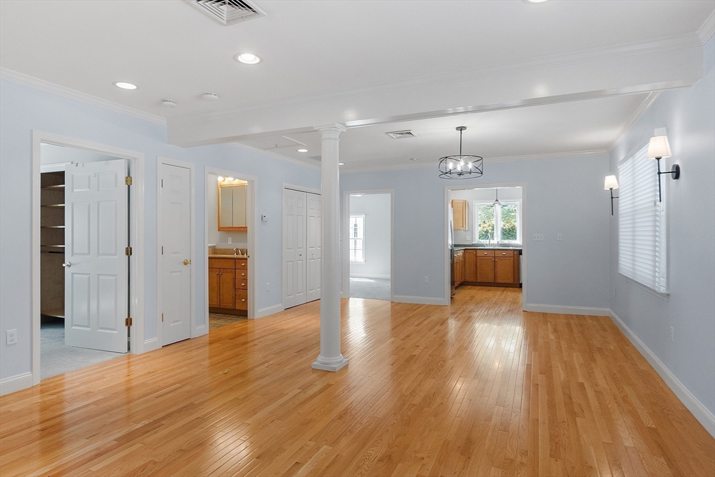 40 Grandview Road Chelmsford, MA 01824 - Photo 38 of 42 a view of an empty room and a kitchen with wooden floor and a ceiling fan