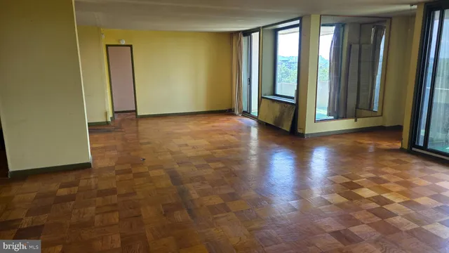 a view of an empty room with wooden floor