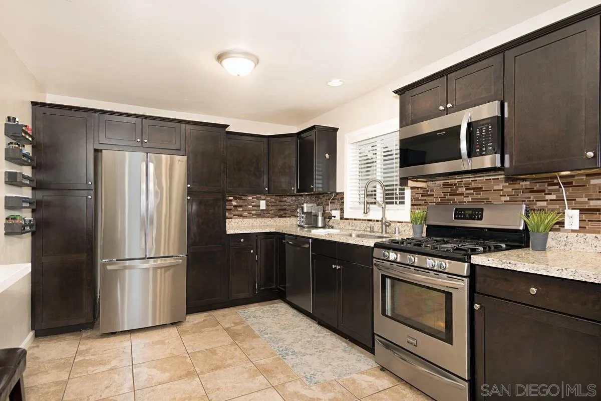 14112 Frame Road Poway, CA 92064 - Photo 11 of 30 a kitchen with stainless steel appliances granite countertop a refrigerator stove top oven a sink and dishwasher