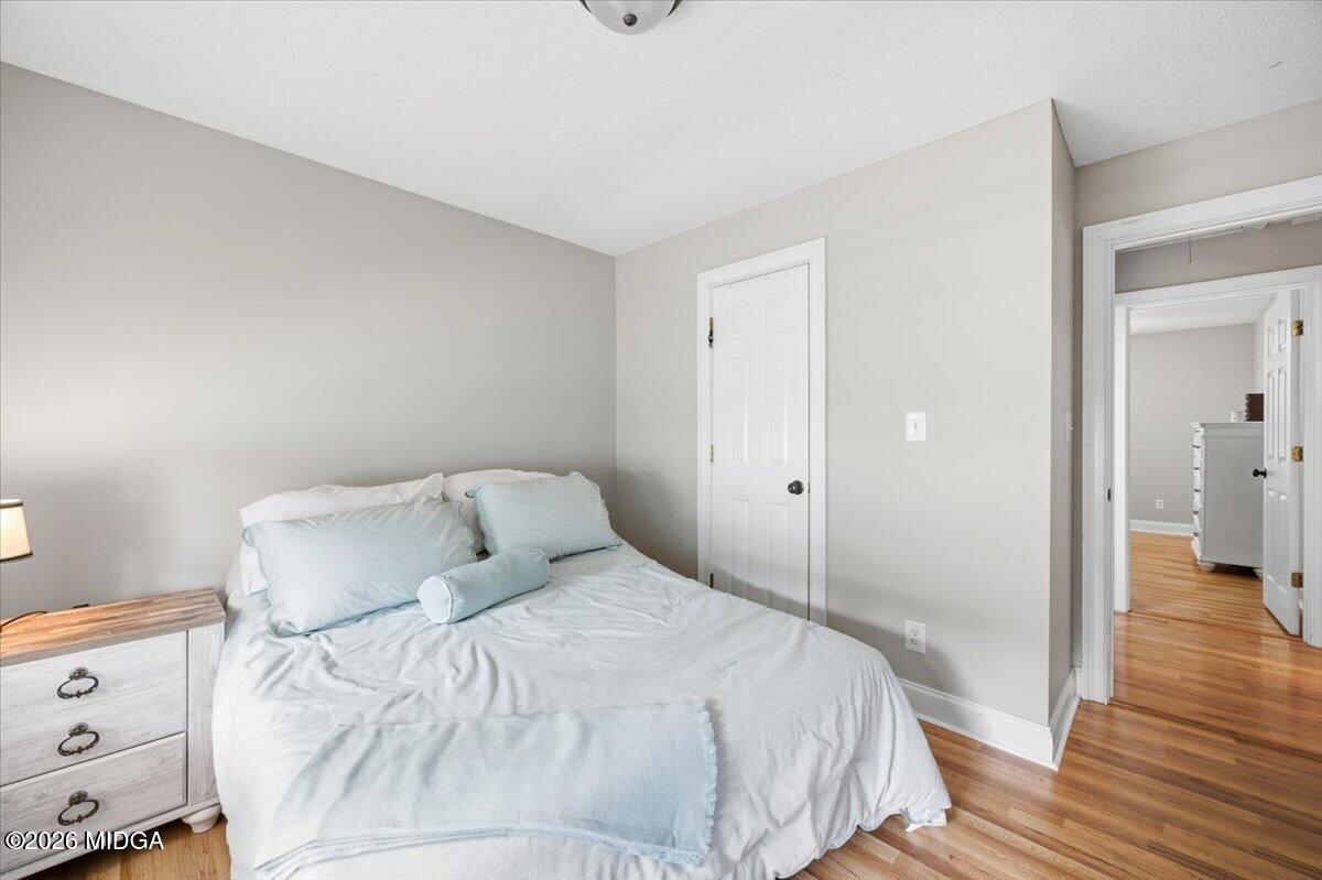 557 Aarons Circle Gray, GA 31032 - Photo 22 of 36 a bedroom with a bed and wooden floor