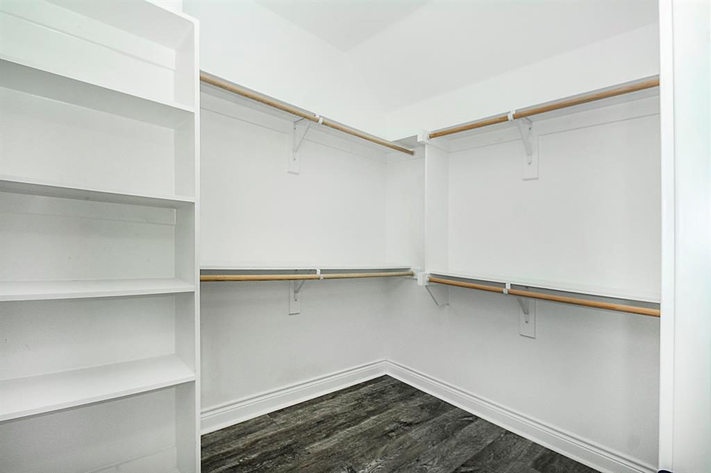 806 Ransom Way Greenville, TX 75402 - Photo 20 of 27 Custom closet featuring built-in shelving, multiple hanging rods, and wood-finish flooring