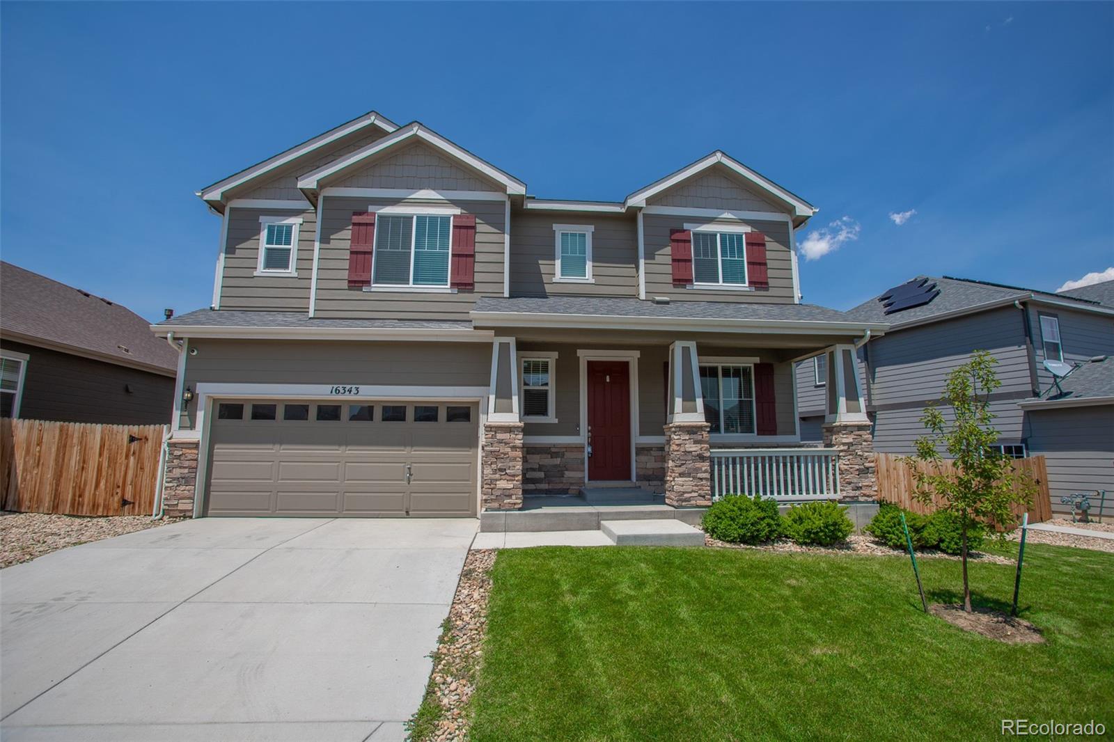16343 East 100th Way Commerce City, CO 80022 - Photo 1 of 38 a front view of a house with a yard and garage