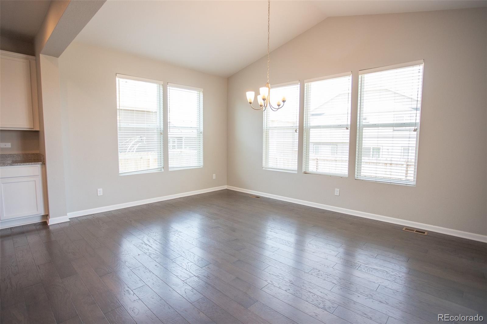 16343 East 100th Way Commerce City, CO 80022 - Photo 11 of 38 an empty room with wooden floor and windows
