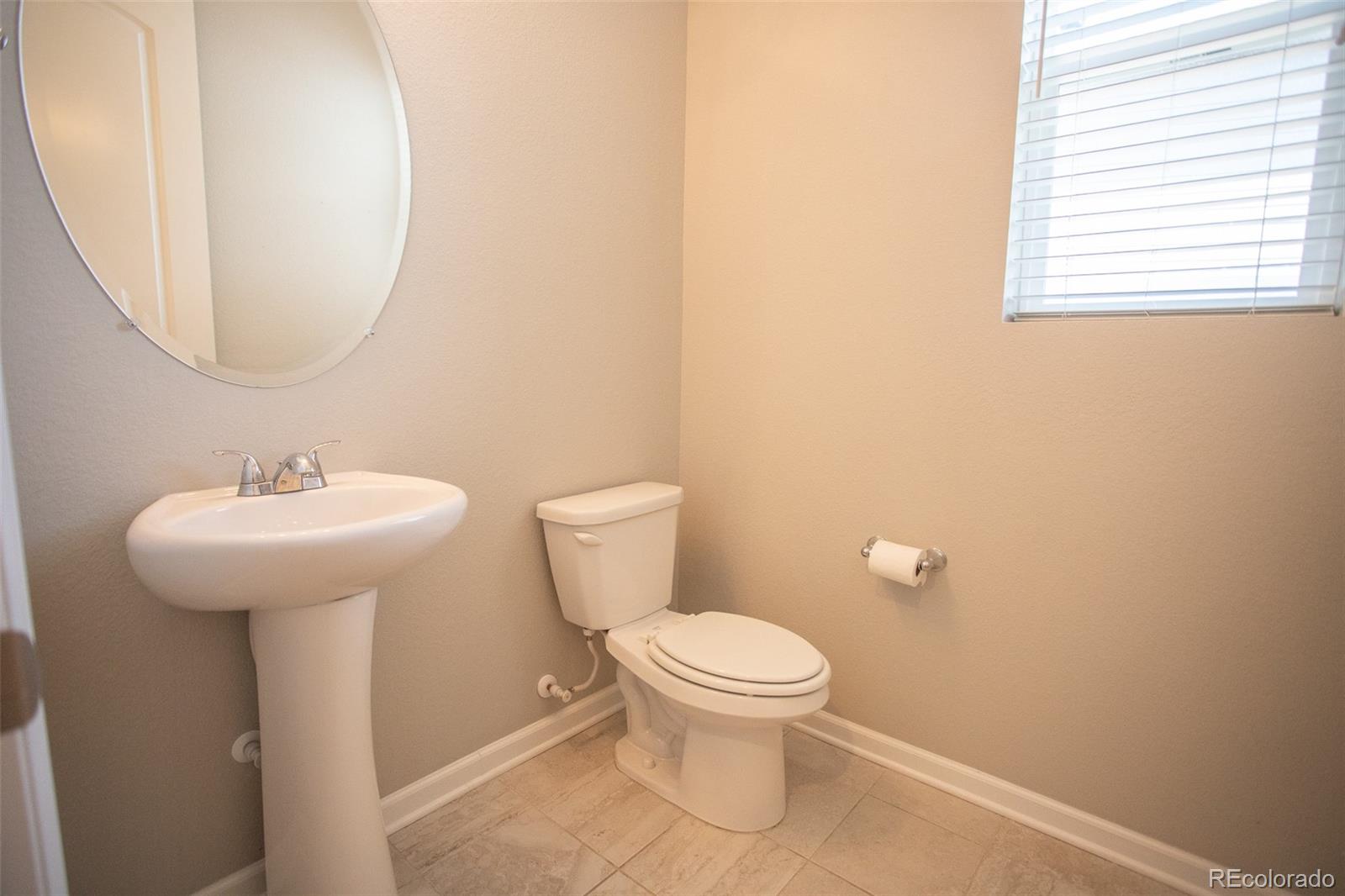 16343 East 100th Way Commerce City, CO 80022 - Photo 12 of 38 a bathroom with a toilet sink and mirror