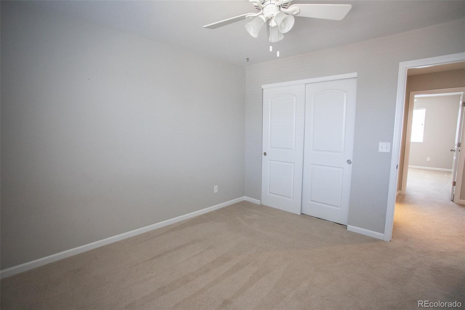 16343 East 100th Way Commerce City, CO 80022 - Photo 21 of 38 an empty room with a chandelier fan