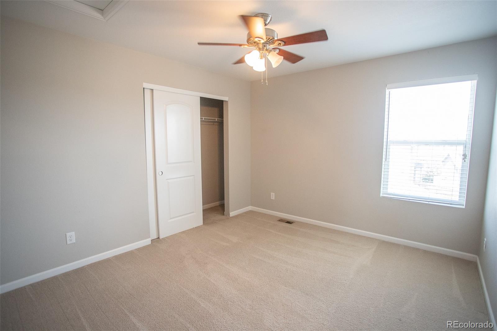 16343 East 100th Way Commerce City, CO 80022 - Photo 24 of 38 an empty room with a window and a fan