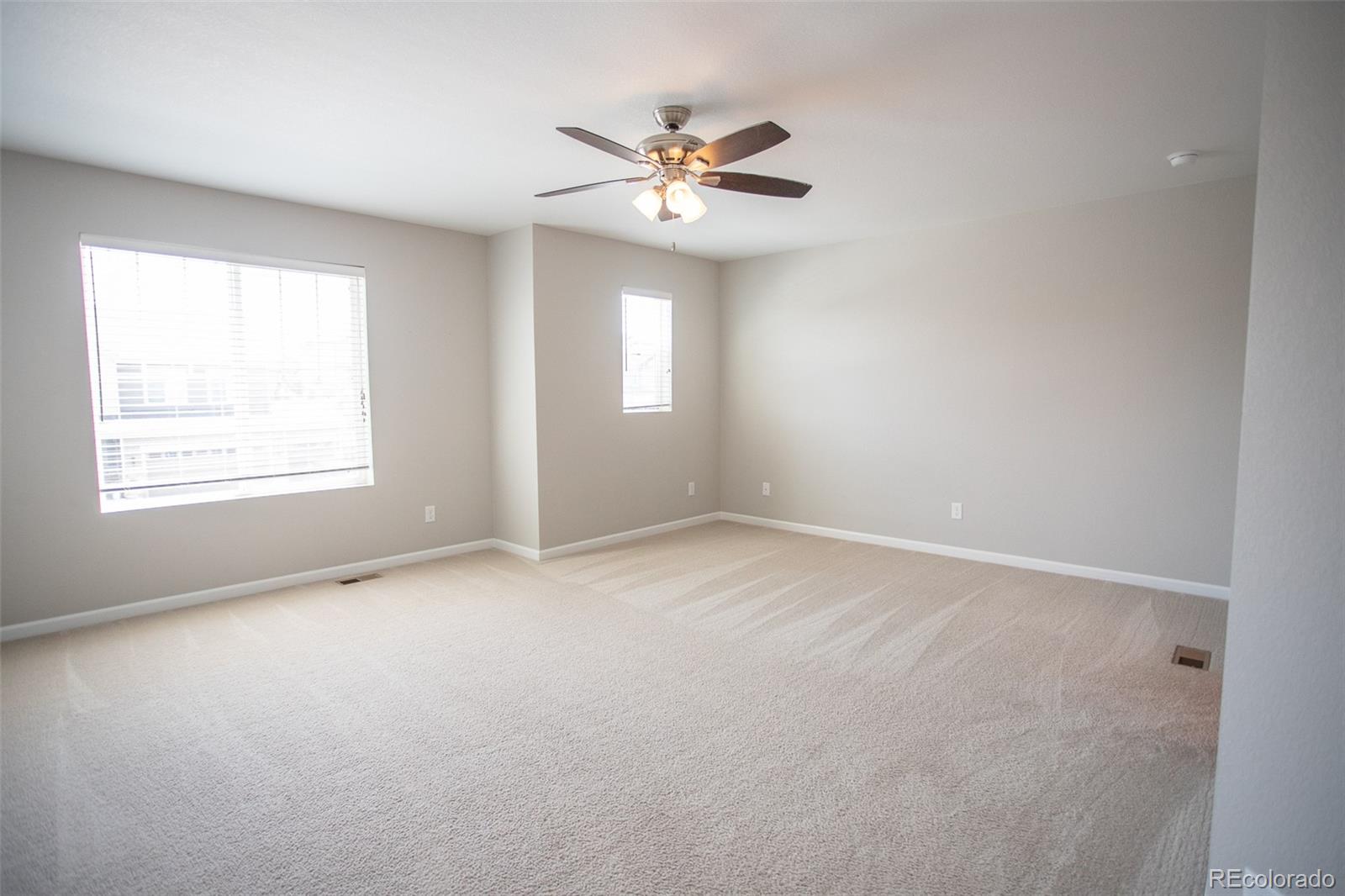 16343 East 100th Way Commerce City, CO 80022 - Photo 25 of 38 an empty room with a window and a ceiling fan