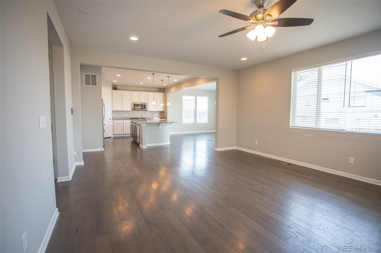 16343 East 100th Way Commerce City, CO 80022 - Photo 5 of 38 wooden floor in an empty room with a window