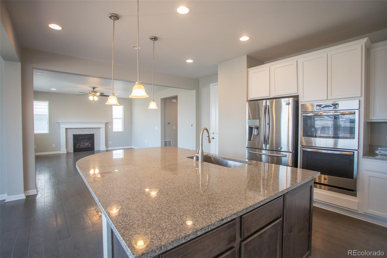 16343 East 100th Way Commerce City, CO 80022 - Photo 8 of 38 a kitchen with stainless steel appliances granite countertop a refrigerator a sink and a stove