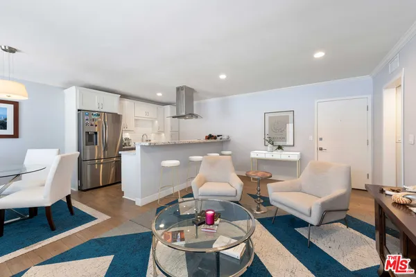 a living room with furniture and a dining table with kitchen view
