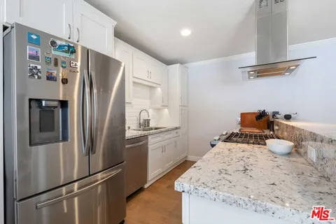 a kitchen with stainless steel appliances a refrigerator and a stove top oven