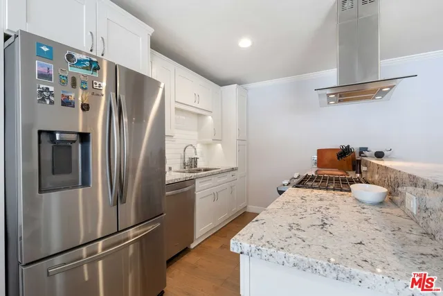 a kitchen with stainless steel appliances a refrigerator and a stove top oven
