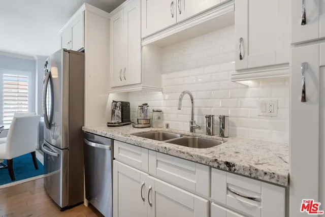 a kitchen with granite countertop a sink and cabinets