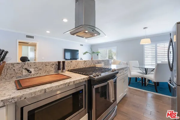 a kitchen with a stove and a wooden floors
