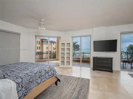 a spacious bedroom with a bed and a flat screen television