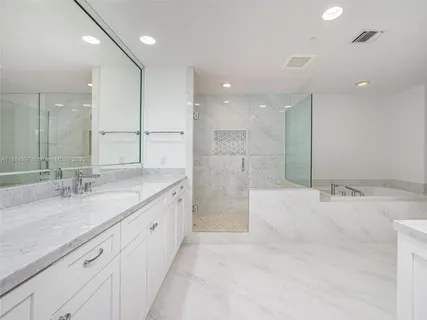 a bathroom with a granite countertop sink mirror and shower