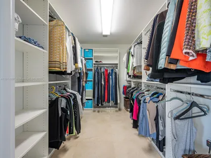 a view of walk in closet with clothes