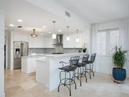 a kitchen with a white cabinets and chairs in it