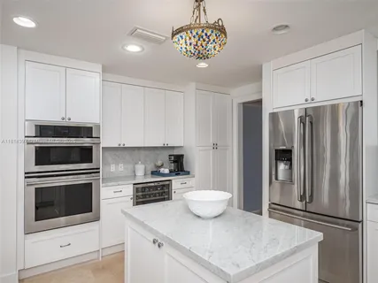 a kitchen with a sink stainless steel appliances and white cabinets